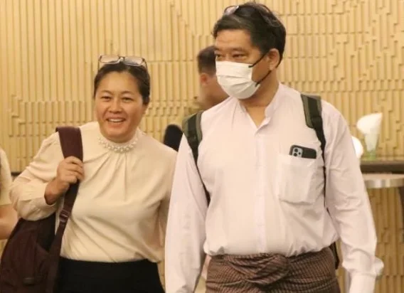 Two people walking together at an indoor gathering