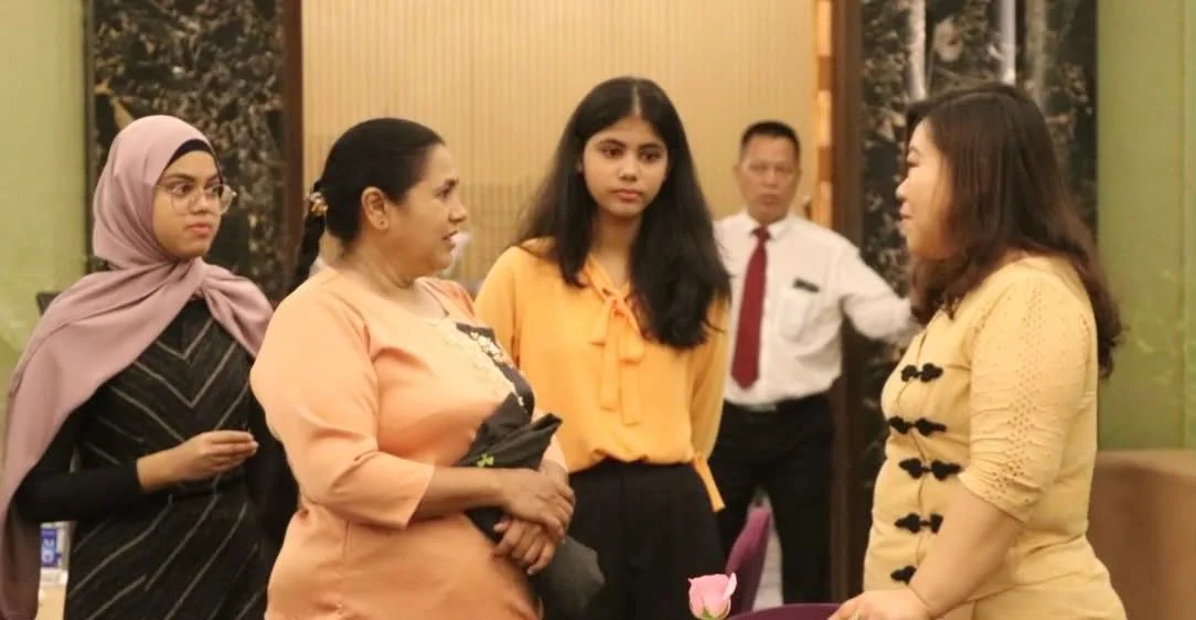 Four people talking at an indoor gathering